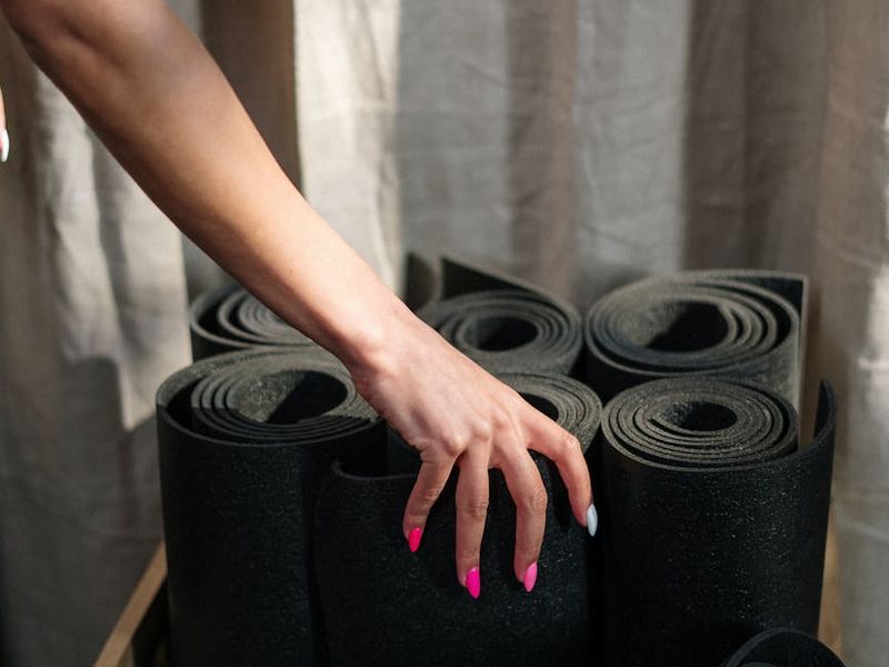 Detailed close-up of hands on a yoga mat during stretching.